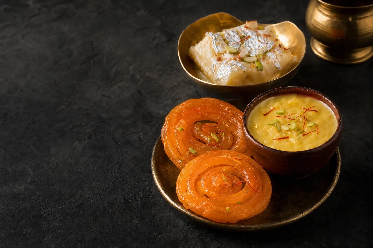 Brass thali of jalebi, shahi tukda and saffron phirni